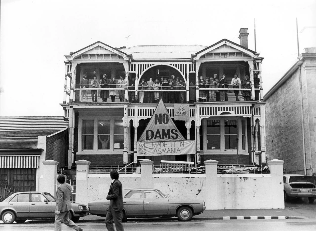 B&W image of building with NO DAMS banners hanging off the side
