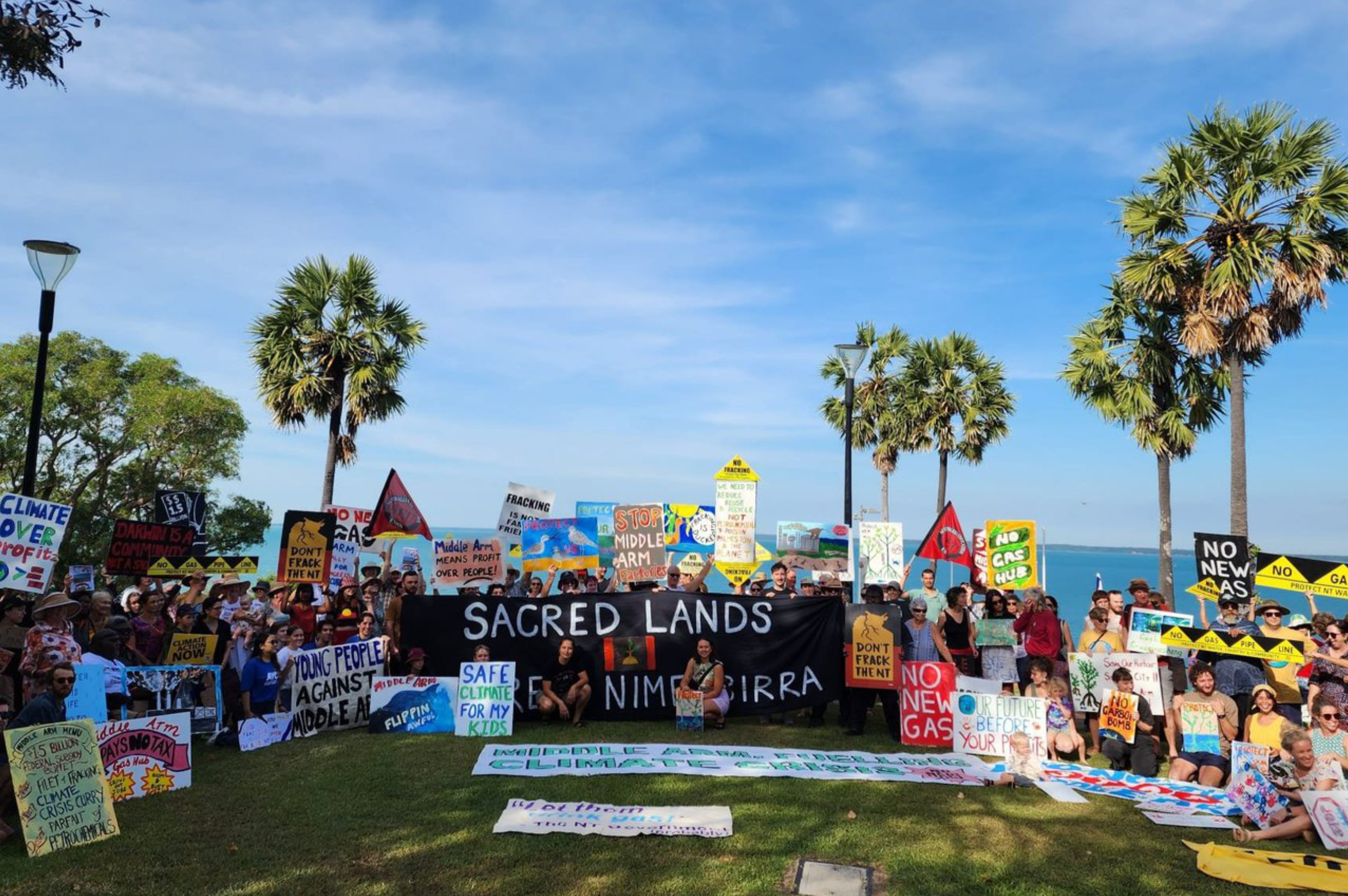 Group photo of 100's of project supporters with various banners.